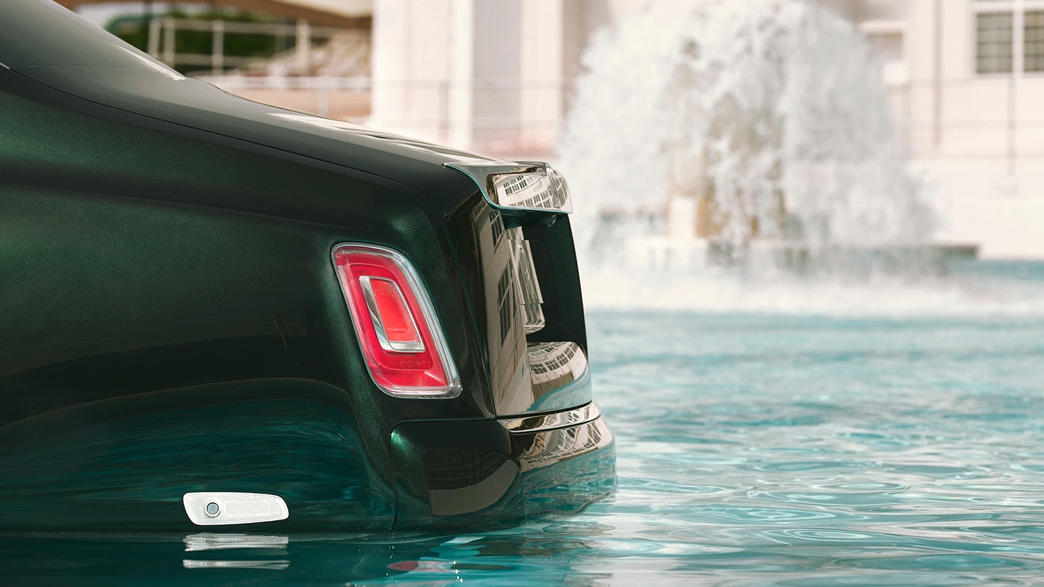 tylny fragment nadwozia Rolls-Royce Phantom stojącego w wodzie, z charakterystyczną czerwoną lampą