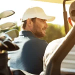 dwaj golfiści na wózku golfowym